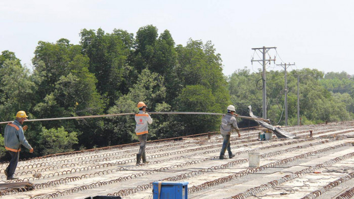Công nhân hối hả làm việc tại các nhịp cầu đã gác dầm bê tông băng xuyên rừng. Đang bó vỉa sắt để đổ bê tông mặt cầu, công nhân Phạm Văn Vùng nói: "Hiện tiến độ đang gấp rút, mùng 7 Tết chúng tôi đã vào công trường làm việc. Nhiều mũi thi công trên cầu và nền đường đang thi công nước rút".